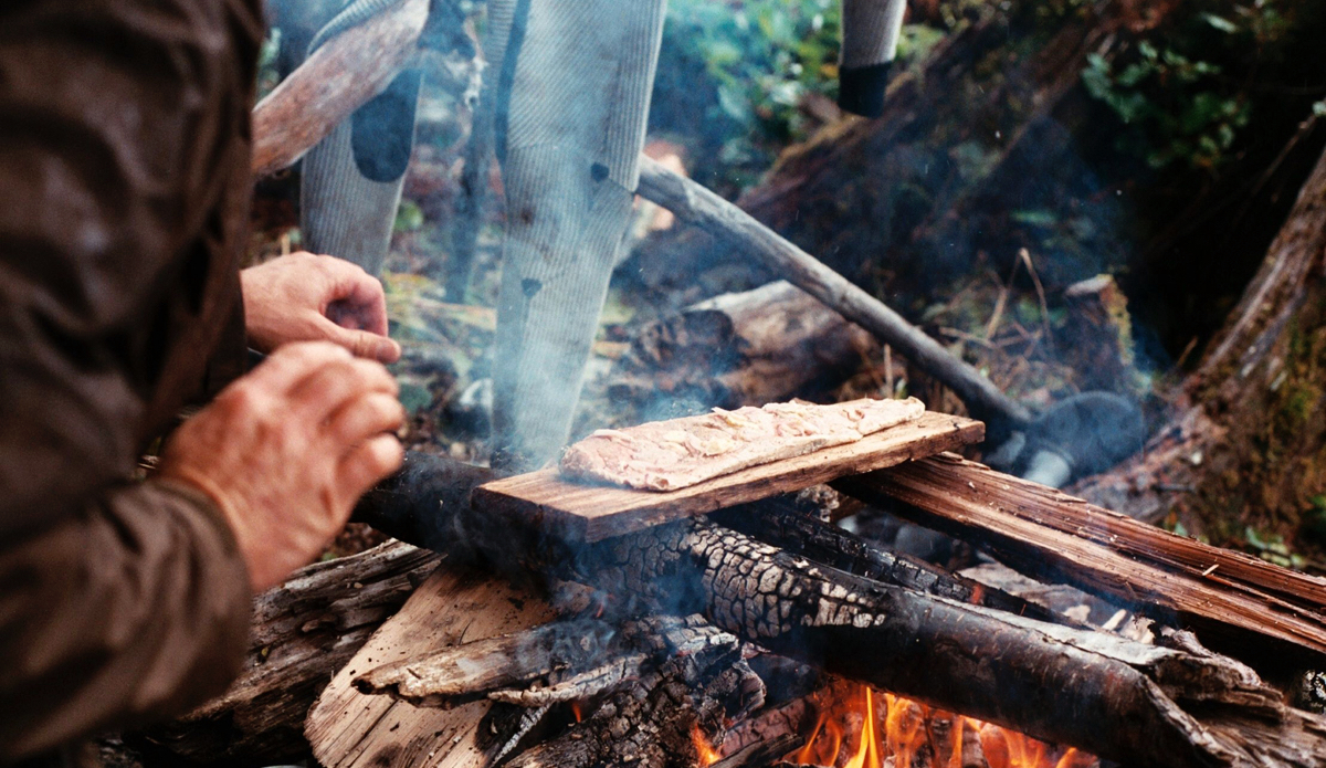 Dan Malloy barbeques some Coho salmon on the beach in British Columbia during a boat trip on the Great Bear Rainforest. Photo: <a href=\"https://trevorgordonarts.com\">TrevorGordonArts.com</a>