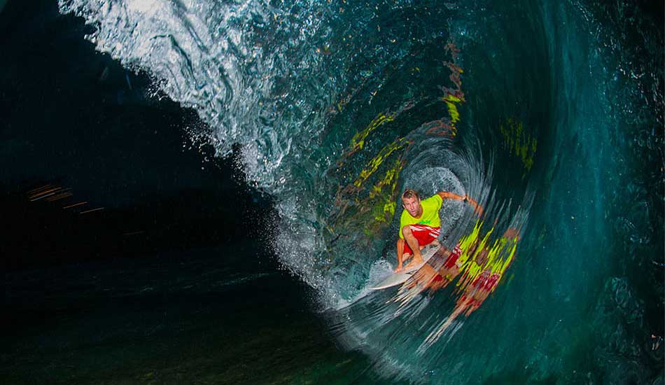 I don\'t normally like to shoot deer-in-headlight-style flash photos, but the clear water allowing you to see the reef below, and the mirror effect happening with the crazy colors deep in the tube makes me like this photo. It’s my brother Jamie at Uluwatu in Bali and having to swim back in and walk up that trail at dark means if you get anything decent, you use it. Photo: <a href=\"http://trevormoran.com/\">Trevor Moran</a>