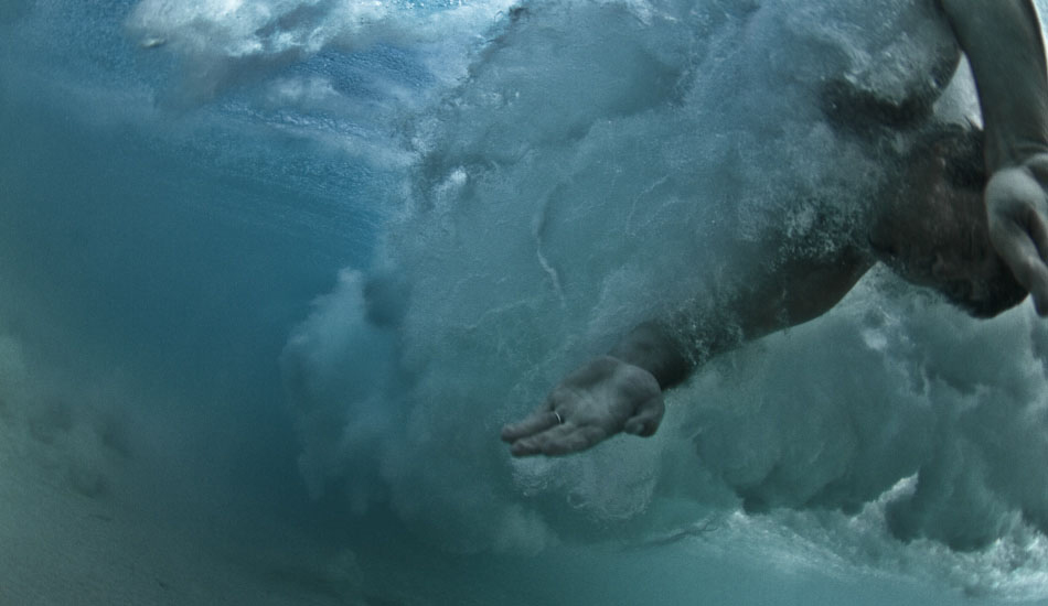 Caught. A surfer struggles against the breaking wave after falling from his board in the South Australian Outback. “On the same first trip with Mike the water didn\'t look too clear, so Mike was surfing and I was shooting - we linked on a smoker and got a pretty cool (standard) surfing photo. Shortly after, a bomb set with a surfer stroking into it caught me inside. I grabbed the sand and tried to be as flat as possible. A split second later he almost hit me, but as he was being pulled away I shoved the camera in his face and fired off a half-dozen shots.” Photo: <a href=\"https://www.marktipple.com/\" target=_blank>Mark Tipple</a>.
