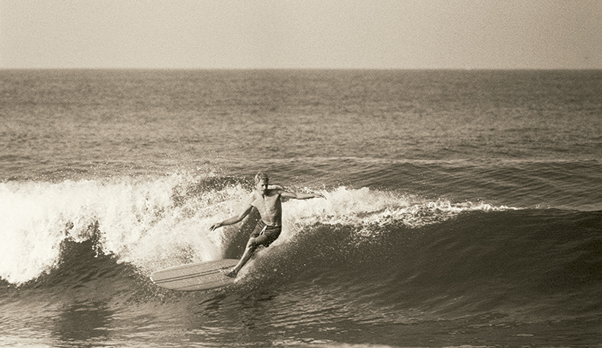 Midget Farrelly at Palm Beach c. 1964
Midget was the first great hero of Australian surfing. If his influences were Californian (the Phil Edwards multi-stringered boards and the Peter Van Dyke drop-knee cutback), he put the whole package together with a great individual style.
 Photo: <a href=\"https://www.johnwitzig.com.au/\">John Witzig</a>