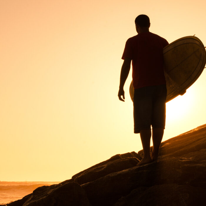 Surfer looks back at sunset.