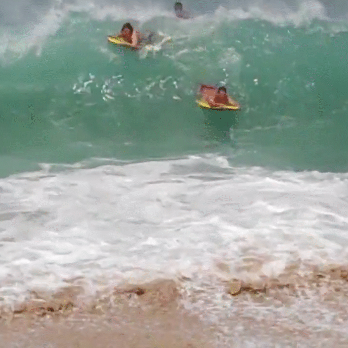Tourists get smashed at Waimea Bay.