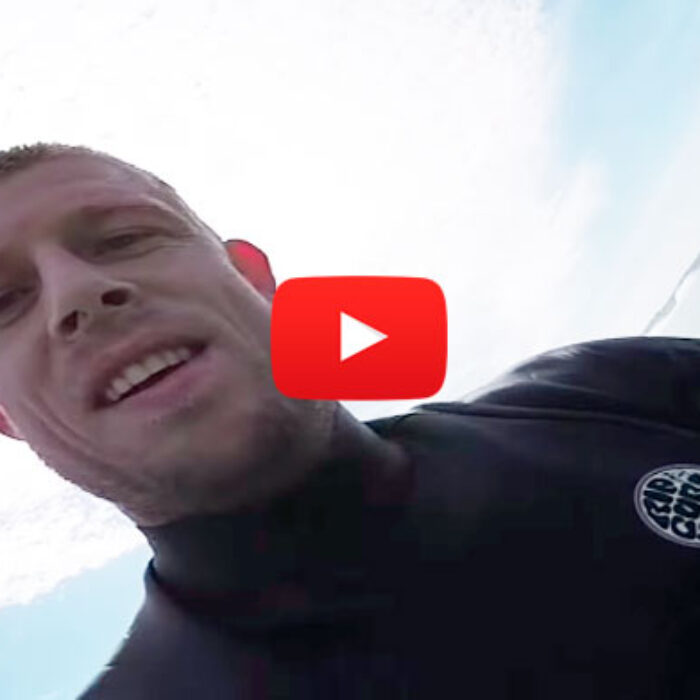 Mick Fanning grinning ear to ear and enjoying the fruit of his labor by taking a victory lap.