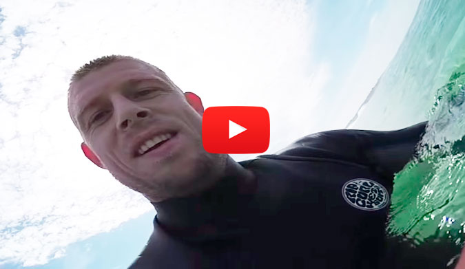 Mick Fanning grinning ear to ear and enjoying the fruit of his labor by taking a victory lap.