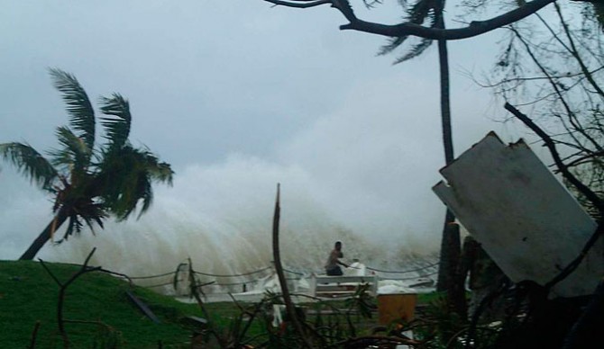 A man runs from Pam's fury, Photo: CARE Australia