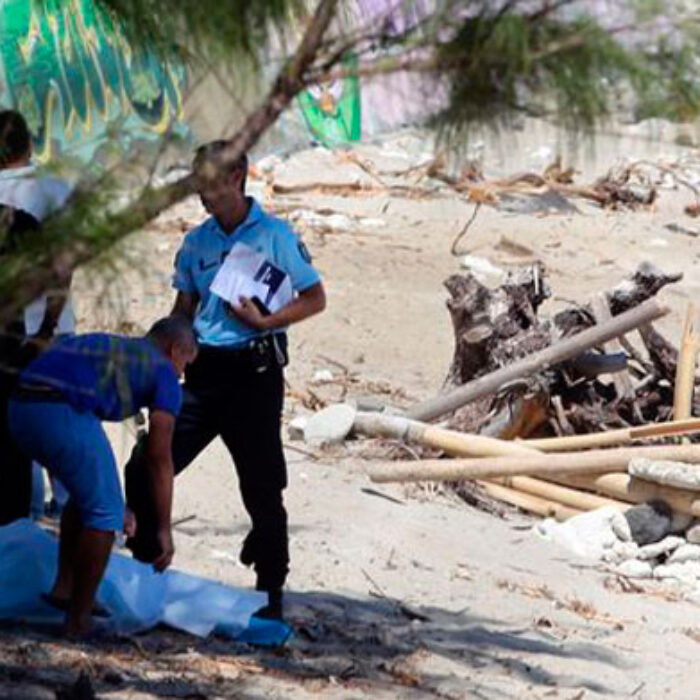 Police stand over the body of Elio Canestri shortly after the attack.