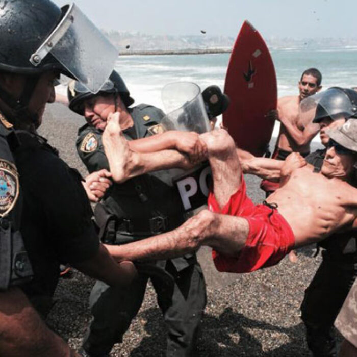 Surfers clash with riot police over a beach being destroyed to protect a roadway.
