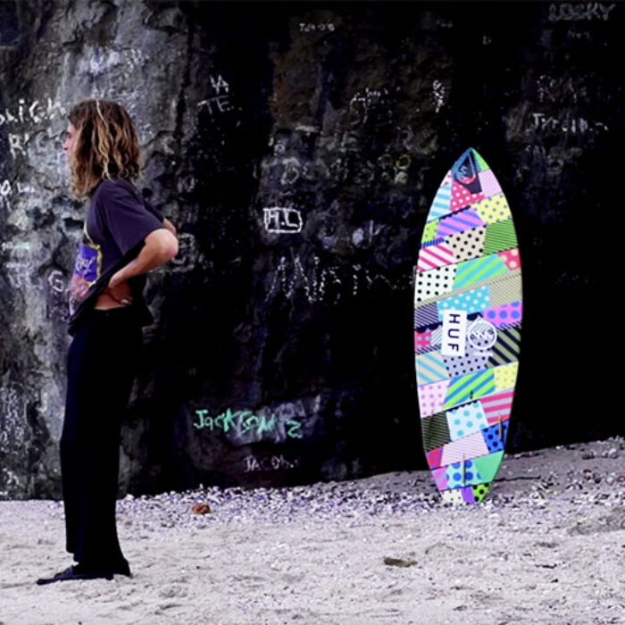 An artist on a surfboard painted by an artist.