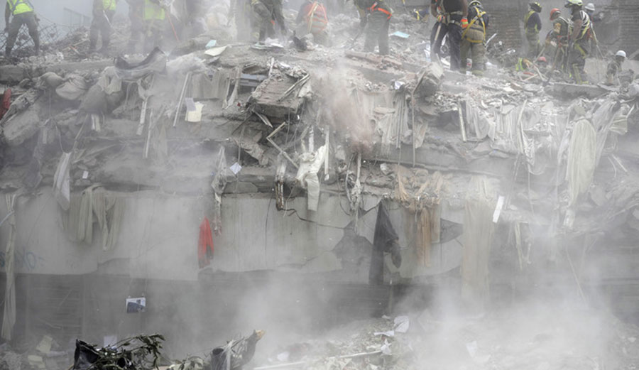 Workers clear debris on Sept. 25, 2017 from the top of a building that collapsed in Mexico City after the Sept. 19 earthquake.