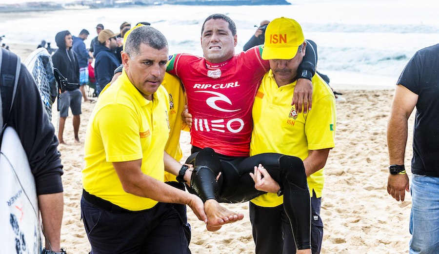 Adriano de Souza gets carted up the beach after suffering an injury while heading out for his 2018 MEO Rip Curl Pro Portugal Round 2 heat. Photo: WSL/Masurel