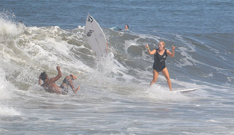 Woman surfer dropping in on wave.