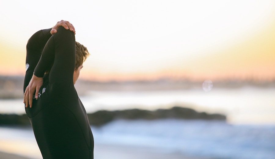 Surfer stretching on the beach