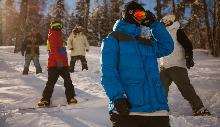 Snowboarders waiting to ride down.