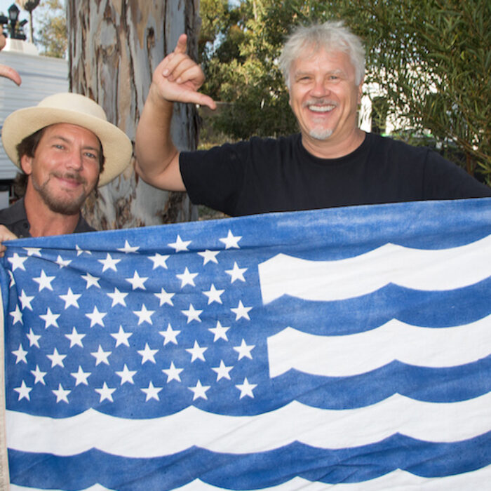 Eddie Vedder and Tim Robbins pose with Surfrider's USOA Flag