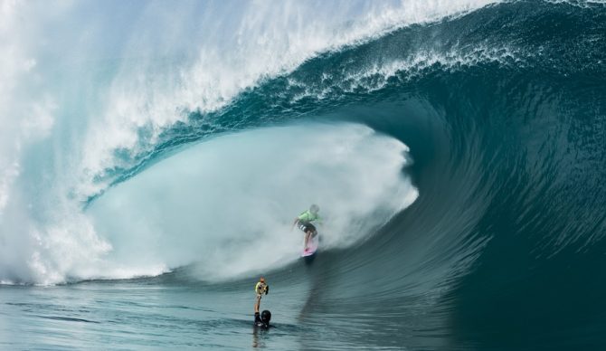 brent bielmann shooting from the water with a surfer in the barrel
