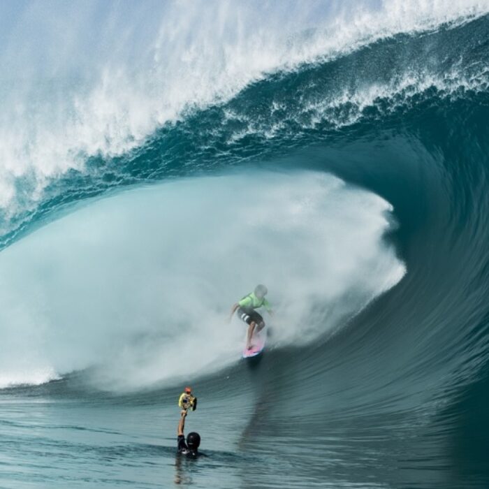 brent bielmann shooting from the water with a surfer in the barrel