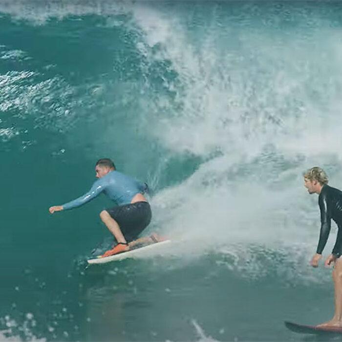 John John Florence surfing at Backdoor with body boarder in front of him