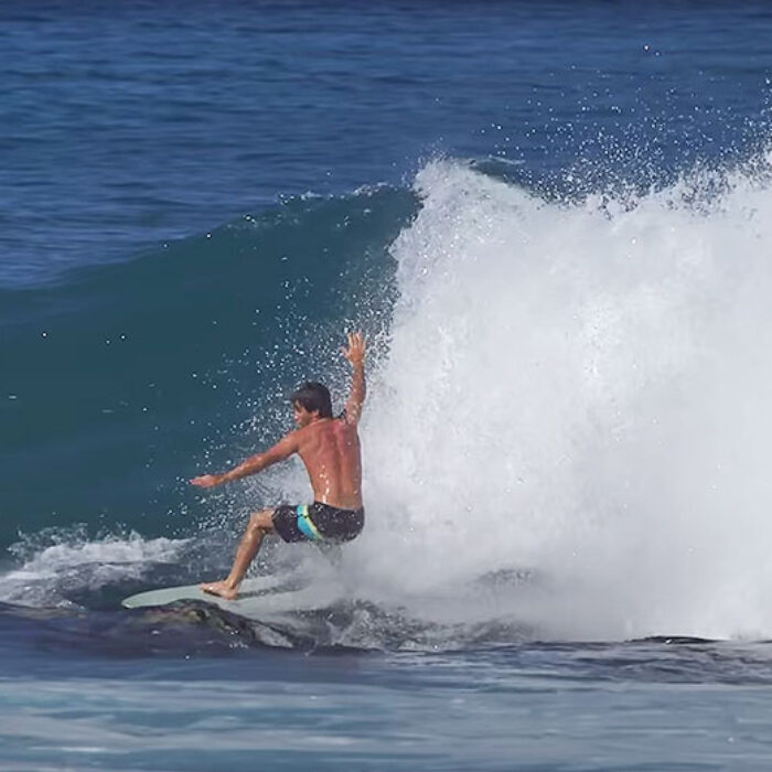 Mason Ho surfing on rocks on foam surfboard