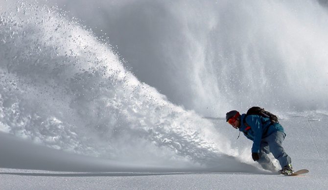 a snowboarder rides powder