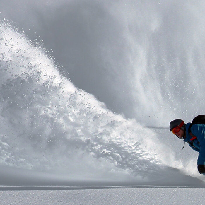 a snowboarder rides powder