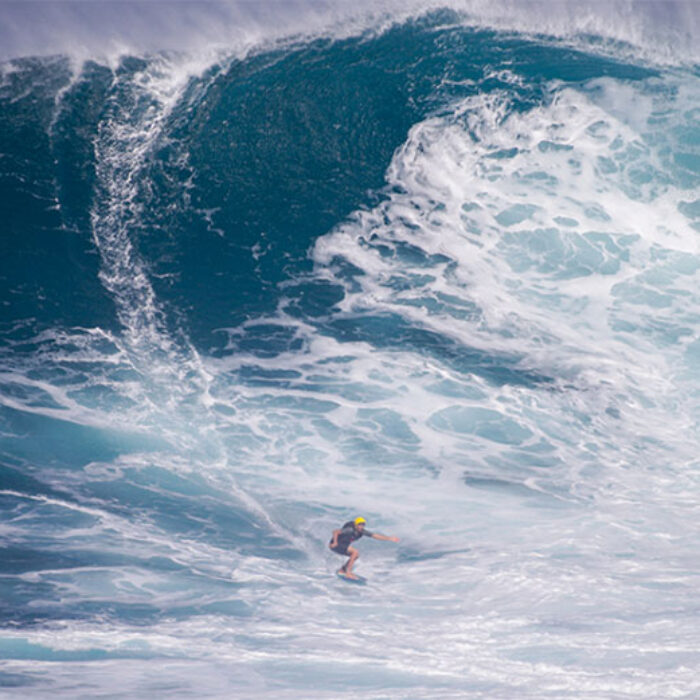 Sean McClenahan riding massive Jaws on a skimboard.
