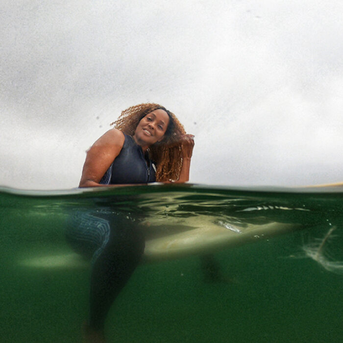 Mimi Miller, organizer of Indigenous Beach Culture Film Festival on a surfboard