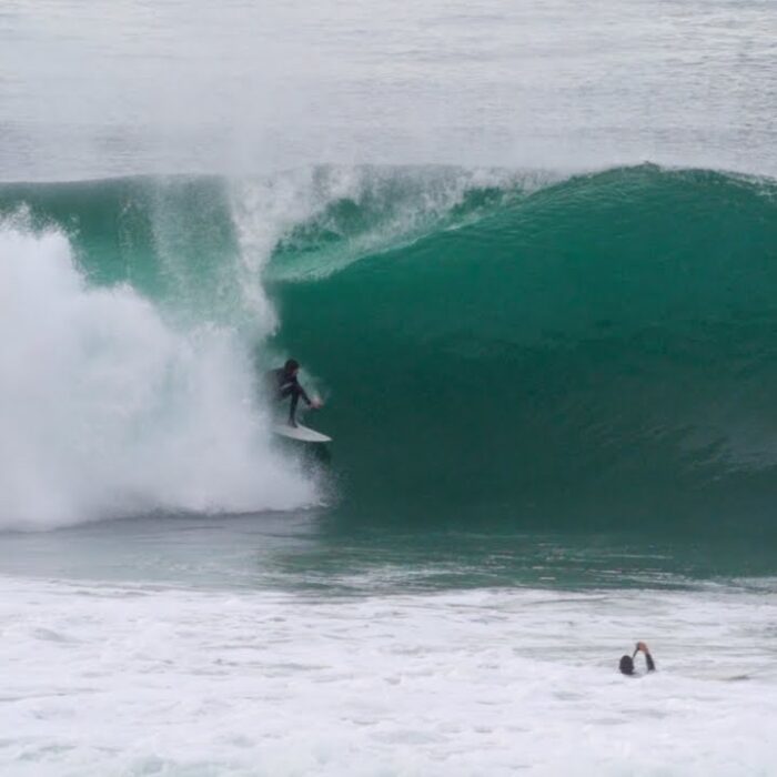 A surfer pulls into a barrel at Blacks Beach