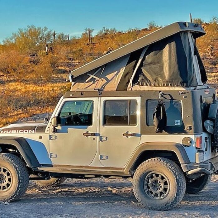A 4x4 Jeep with a pop-top camper