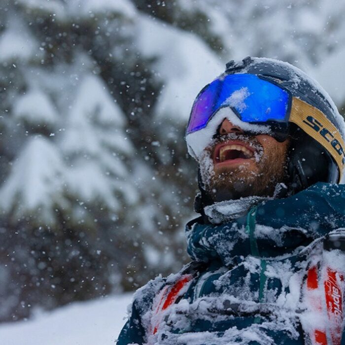 stoked dude in the snow with snow on his face skiing