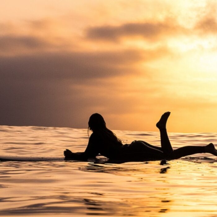 on a longboard at sunset