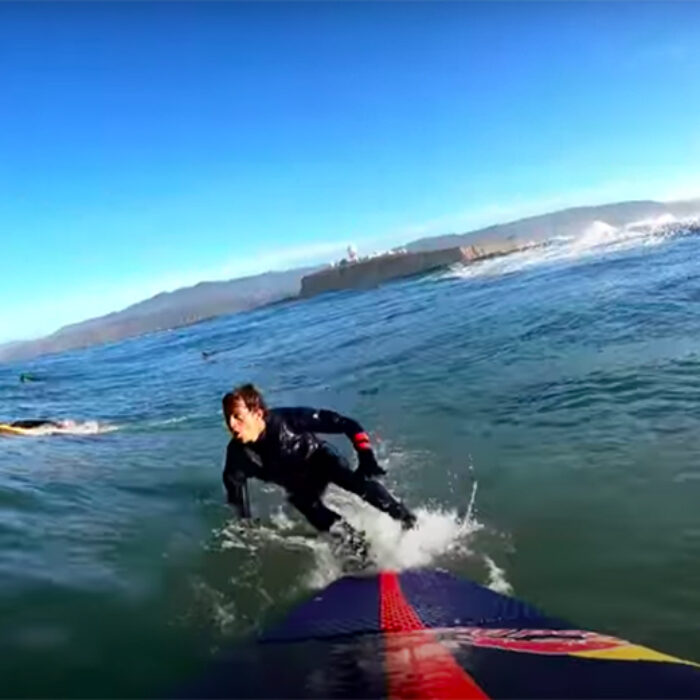 Kai Lenny bails off his board to dive under a giant wave at Maverick's