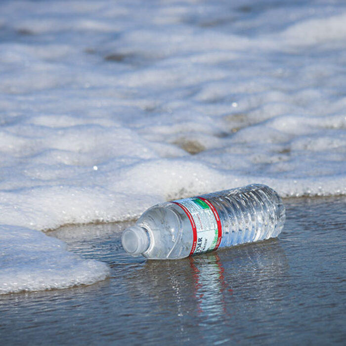 Plastic water bottle at ocean's edge