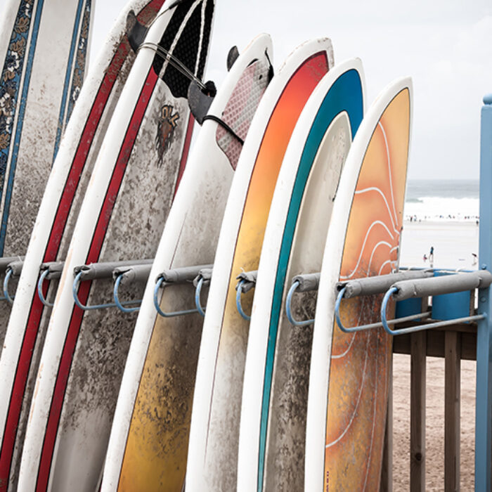 Composite surfboards sit in a rental rack