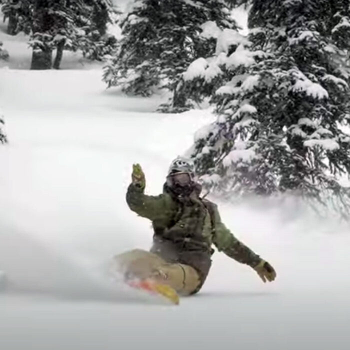 Bryan Fox with a beautiful turn in powder on a snowboard