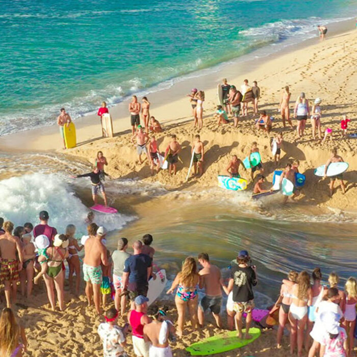 Crowd of people watching Waimea River surfers
