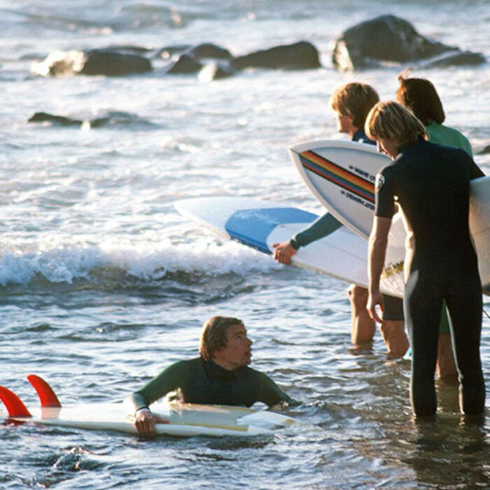 surfers with surfboards getting in the water