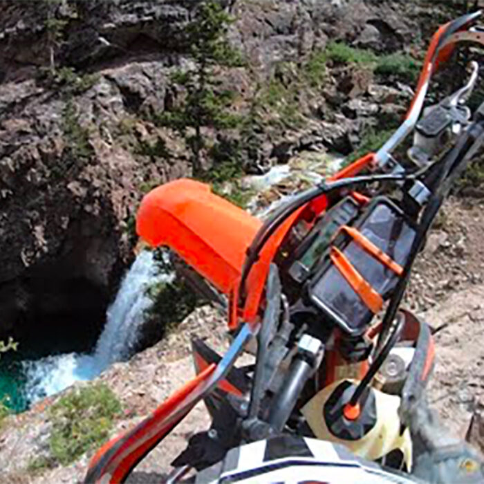 A dirtbike about to fall 100 feet into a waterfall pool