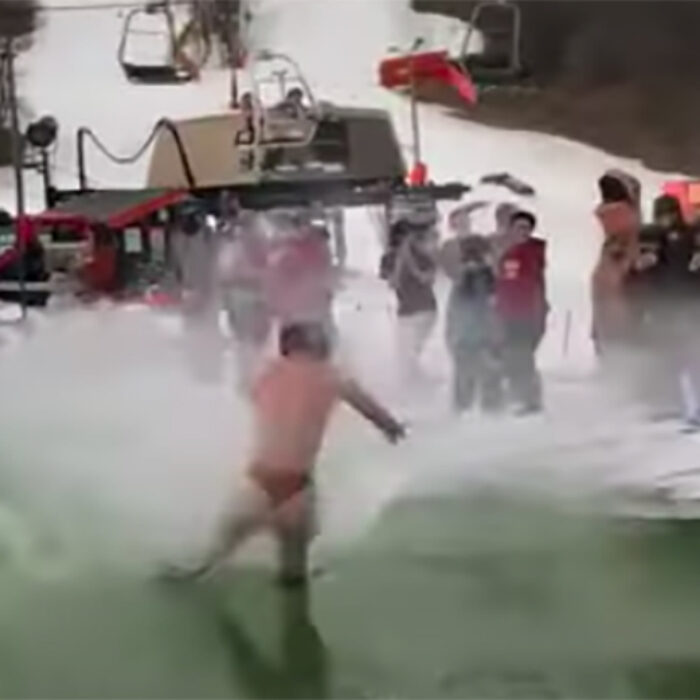 A snowboarder crashes during a pond skim