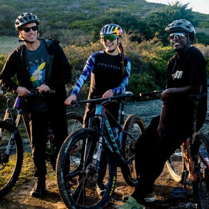 Jeremy Searle and Luis Medearis pose for a shot with World Champion Mountain Biker, Kate Courtney, after a grueling climb in Marin County, CA.
