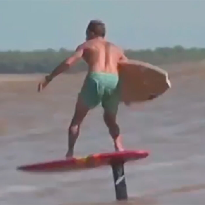 a foiler performs a board transfer on a tidal bore
