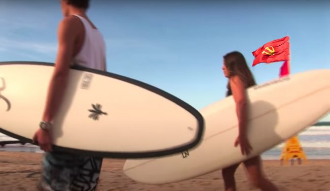Two surfers in front of a commmunist flag