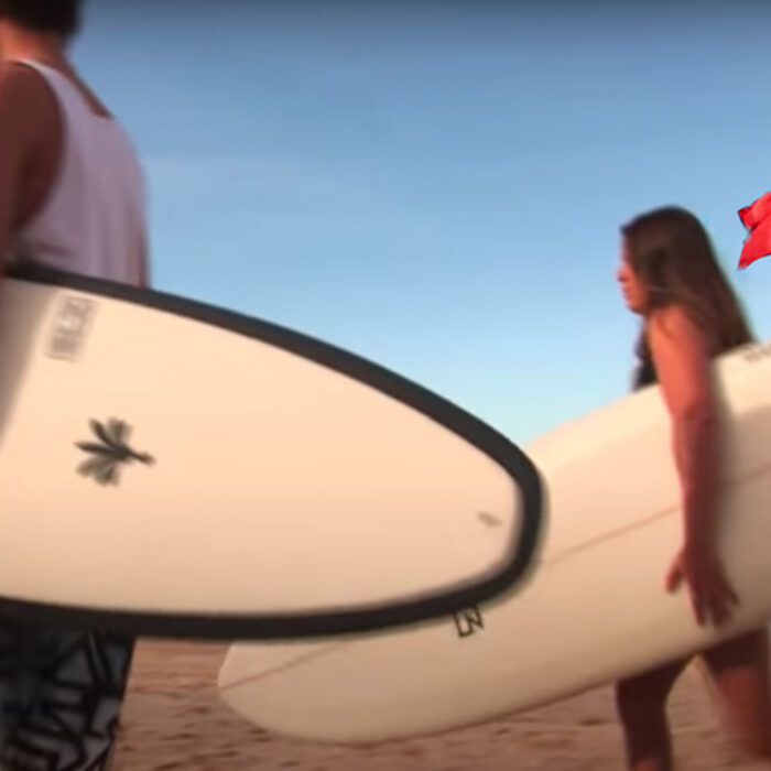 Two surfers in front of a commmunist flag