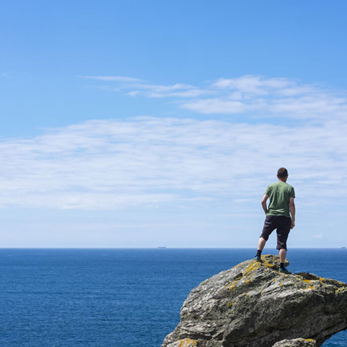 Man on rock looking at ocean
