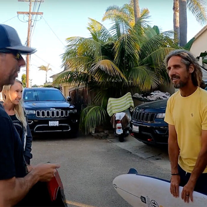 Rob Machado giving Pete Gustin a surfboard