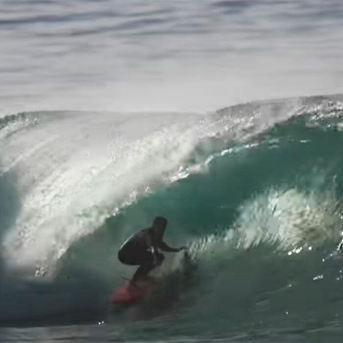 a surfer rides a barrel