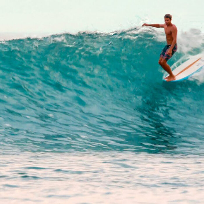 A longboarder rides a wave in Mexico