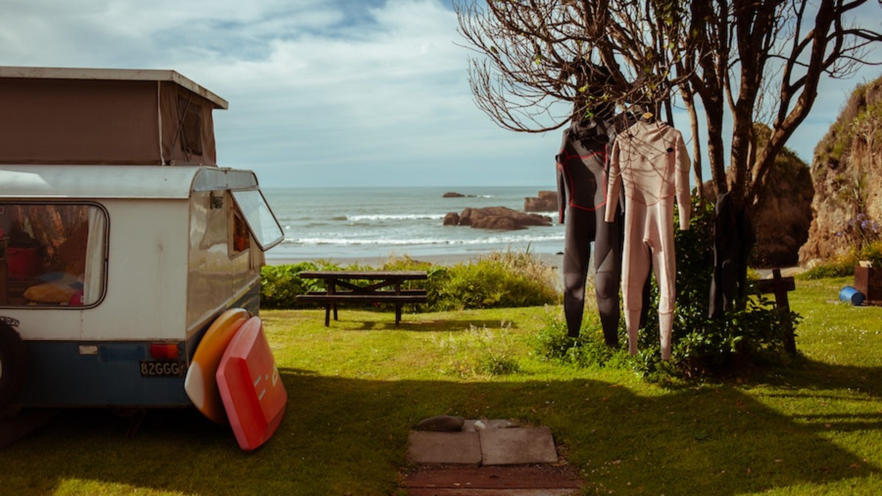 wetsuits hanging at a campsite