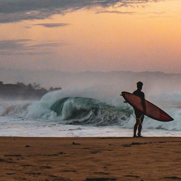 Surfer looking at ocean thinking about surfing