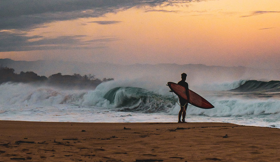 Surfer looking at ocean thinking about surfing