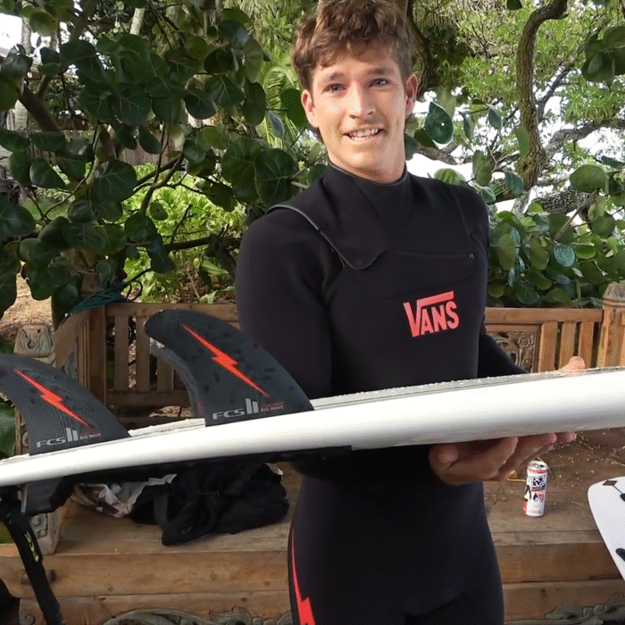 Nathan holds up his surfboard with his new FCS II fin set-up.